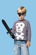 Photo: Portrait of a young boy in pirate costume holding sword over blue background Portrait of a young boy in pirate costume holding sword over blue background