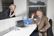 Photo: Middle-aged businessman throwing paper airplane towards female colleague in office Middle-aged businessman throwing paper airplane towards female colleague in office