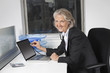 Photo: Portrait of senior businesswoman examining laptop with the use of stethoscope at office desk Portrait of senior businesswoman examining laptop with the use of stethoscope at office desk