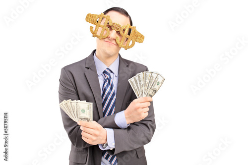 Photo: A young man wearing dollar sign glasses and holding US dollars A young man wearing dollar sign glasses and holding US dollars