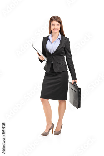 Photo: Full length portrait of a businesswoman with clipboard holding a Full length portrait of a businesswoman with clipboard holding a