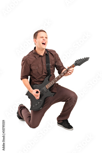 Photo: Full length portrait of a rock star playing a guitar Full length portrait of a rock star playing a guitar