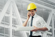 engineer with blue prints and cell phone