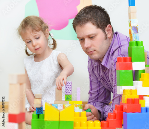 Photo: Father and daughter playing with coloured blocks. Father and daughter playing with coloured blocks.