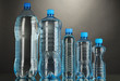 Different water bottles on grey background