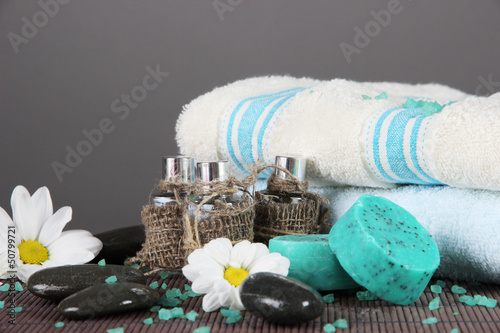 Photo: Oil spa towels on bamboo mat on gray background Oil spa towels on bamboo mat on gray background