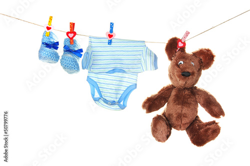 Photo: Baby clothes hanging on clothesline, isolated on white Baby clothes hanging on clothesline, isolated on white