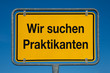 Ortsschild mit blauem Himmel WIR SUCHEN PRAKTIKANTEN