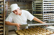 Female baker baking bread rolls