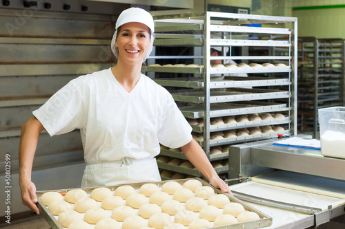 Photo: Female baker baking bread rolls Female baker baking bread rolls