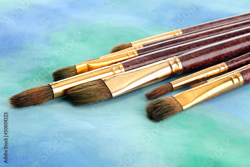 Photo: brushes on bright abstract gouache painted background brushes on bright abstract gouache painted background