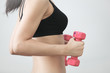 The girl in sportswear is engaged in the gym with dumbbells