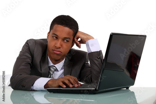 Photo: Bored businessman sat at his desk Bored businessman sat at his desk