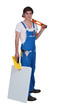 Young tradesman posing with his tools and materials