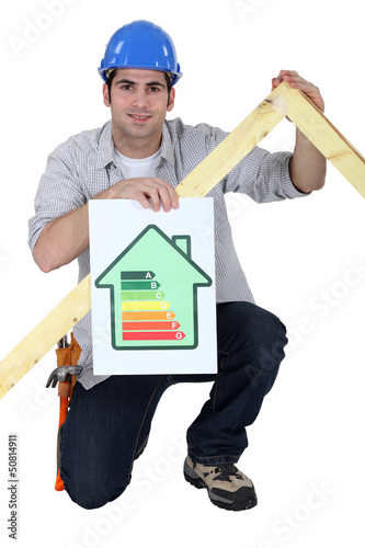Photo: Carpenter kneeling with energy efficiency banner Carpenter kneeling with energy efficiency banner