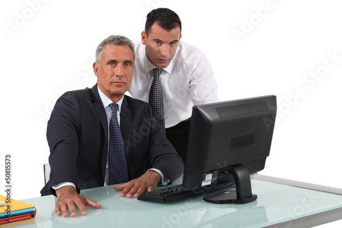 Photo: Office workers in front of a desktop computer Office workers in front of a desktop computer
