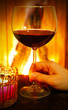 Glas Rotwein am Kamin trinken