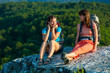 Two trekkers took a rest at the stone in Crimea mountains