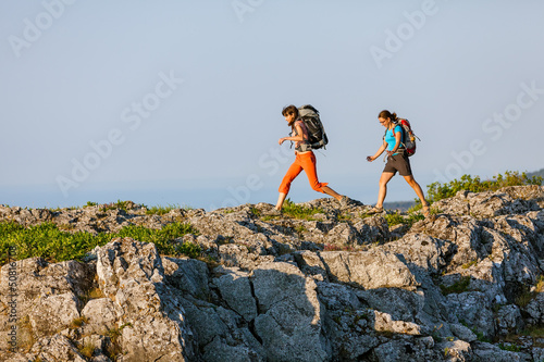 Photo: Two women is trekking in the Crimea mountains with backpacks Two women is trekking in the Crimea mountains with backpacks