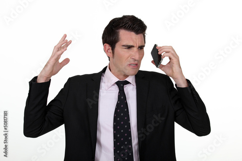 Photo: An angry businesswoman over the phone. An angry businesswoman over the phone.