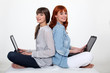 Two young women with laptops