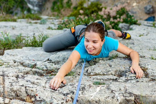 Photo: Woman practices in climbing at the rock in the Crimea mountains Woman practices in climbing at the rock in the Crimea mountains