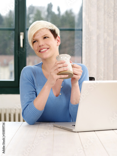Photo: Smiling female working on a laptop Smiling female working on a laptop