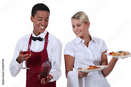 Photo: a wine waiter showing a bottle to a waitress a wine waiter showing a bottle to a waitress