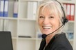 Attraktive Seniorin mit Headset