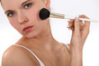 Woman applying blusher with brush