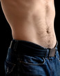 Sporty male belly with jeans closeup photo on black