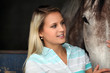 A young woman caressing a horse