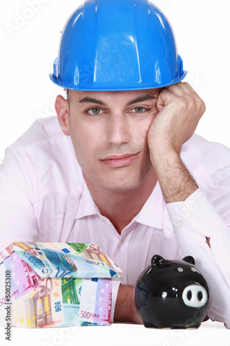 Photo: Pensive man with piggy bank Pensive man with piggy bank