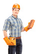 Male construction worker with helmet holding a brick