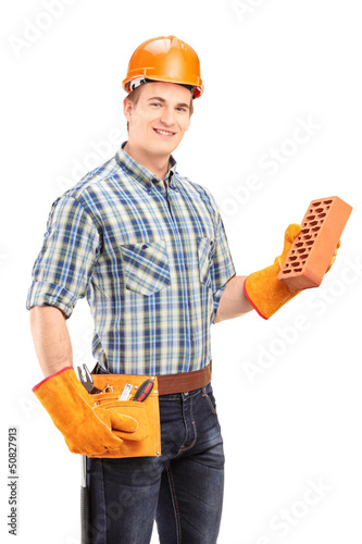 Photo: Male construction worker with helmet holding a brick Male construction worker with helmet holding a brick