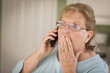 Shocked Senior Adult Woman on Cell Phone in Kitchen