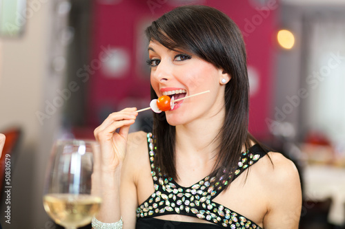 Photo: Beautiful woman eating appetizer in a restaurant Beautiful woman eating appetizer in a restaurant