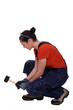 Woman kneeling with mallet