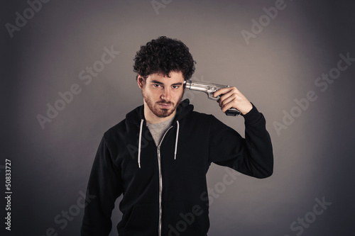 Photo: Young man suicide with gun over dark background. Young man suicide with gun over dark background.