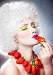 Creative makeup beauty shot of model with strawberries eating