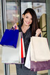 Photo: Beautiful girl holding many shopping bags in front of the mall. Beautiful girl holding many shopping bags in front of the mall.