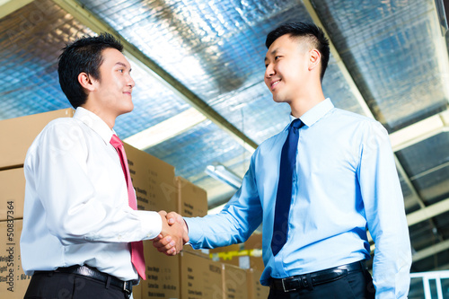 Photo: Businesspeople in warehouse have a deal Businesspeople in warehouse have a deal