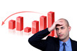 Stressed businessman standing by bar chart
