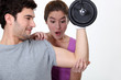 Amazed woman looking at her boyfriend's new muscles