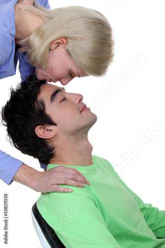 Photo: Woman kissing tenderly man on the forehead Woman kissing tenderly man on the forehead