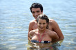 Playful couple frolicking in the sea