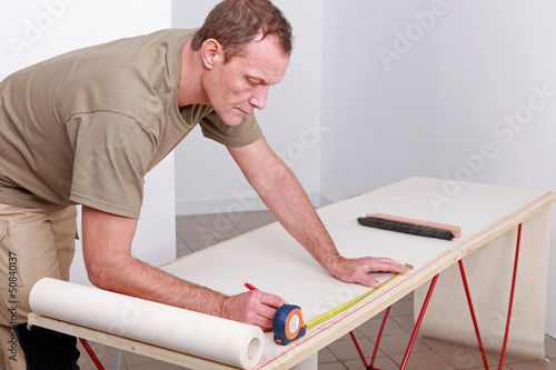 Photo: Man measuring wallpaper Man measuring wallpaper