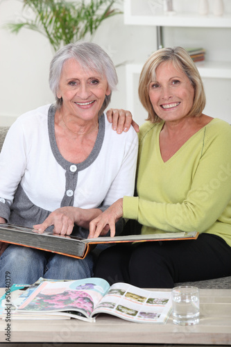 Photo: Mother and daughter looking through photo album Mother and daughter looking through photo album