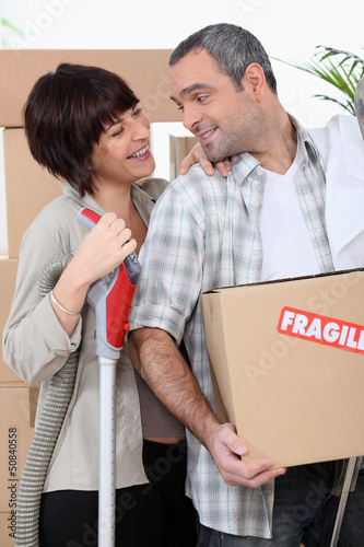 Photo: Couple moving into new home with boxes marked fragile Couple moving into new home with boxes marked fragile
