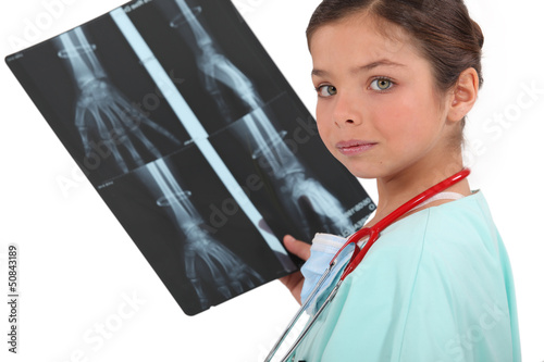 Photo: little girl dressed as a nurse holding a x-ray image little girl dressed as a nurse holding a x-ray image